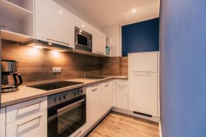 a kitchen with white cabinets and a stove top oven at Hentschels Apartments in Leipzig