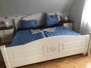 Un dormitorio con una cama con sábanas azules y almohadas azules. en Ferienhaus Ronny, en Hinte