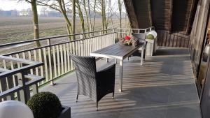 a porch with a table and chairs on a balcony at Große Ferienwohnung, auf Bauernhof mit Ponys und Pferden, ländlich und ruhig, Nähe Dümmer See in Holdorf