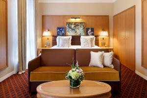 a hotel room with a couch and a bed at Hôtel Barrière Le Westminster in Le Touquet-Paris-Plage