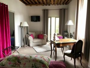 - un salon avec un canapé et une table dans l'établissement Côté-Serein - Les chambres du Clos-Malo, à Noyers-sur-Serein