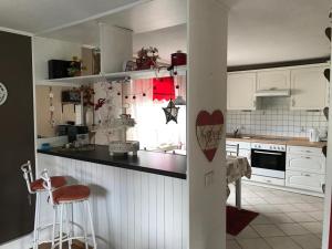 a kitchen with white cabinets and a black counter top at Ferienhaus Ronny in Hinte