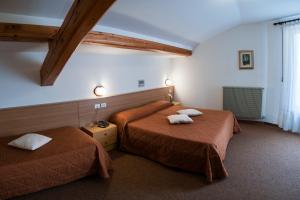 two beds in a hotel room with towels on them at Hotel Rio in Caderzone Terme