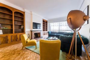 a living room with a blue couch and yellow chairs at ZUBIETA by SWEET HOME SAN SEBASTIAN in San Sebastián