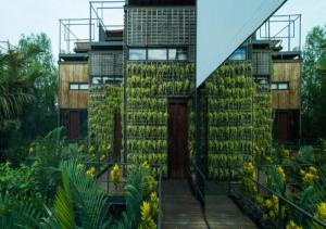 a building with plants on the side of it at Bangkok Tree House Bang Kachao in Bangkok