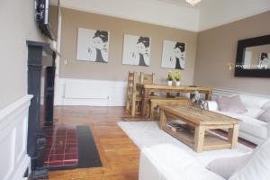 ein Wohnzimmer mit einem weißen Sofa und einem Tisch in der Unterkunft Windsor Street Apartment in Edinburgh
