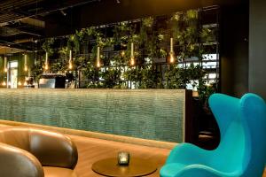a restaurant with chairs and tables in front of the water at Motel One München-East Side in Munich