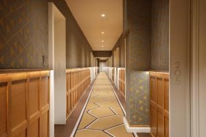 a hallway with blue walls and a tile floor at Hôtel Barrière Le Westminster in Le Touquet-Paris-Plage