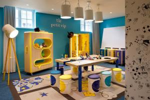 a play room with a table and a yellow refrigerator at Hôtel Barrière Le Westminster in Le Touquet-Paris-Plage