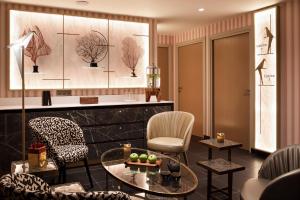 a living room with a table and chairs at Hôtel Barrière Le Westminster in Le Touquet-Paris-Plage