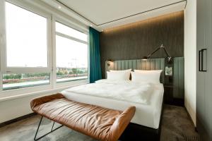 a hotel room with a large bed and a large window at Motel One München-East Side in Munich