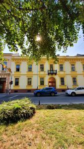 una macchina blu parcheggiata di fronte a un edificio giallo di Apartmani Galea a Sombor