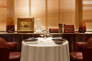 a table in a restaurant with a white table cloth and wine glasses at Hôtel Barrière Le Westminster in Le Touquet-Paris-Plage