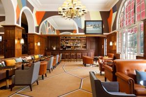 a restaurant with tables and chairs and a bar at Hôtel Barrière Le Westminster in Le Touquet-Paris-Plage