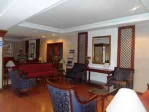 a living room with a red couch and chairs at Hotel Bhimas Paradise in Tirupati