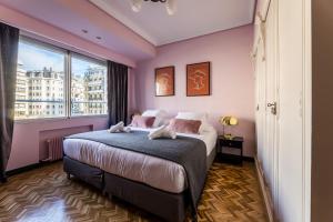 ein Schlafzimmer mit einem großen Bett und einem großen Fenster in der Unterkunft ZUBIETA PLAZA Apartment in San Sebastián