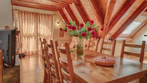 uma mesa de jantar com um vaso de flores em Saplan Real Estate ERA LANA em Les