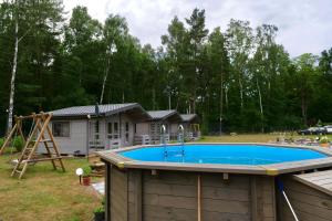 un patio trasero con piscina y una casa en Podlasem21, en Ustka