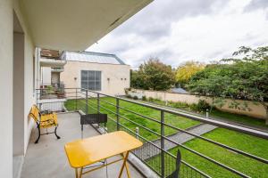 einen Balkon mit einem Tisch und Stühlen sowie Blick auf einen Hof in der Unterkunft Les Petites Canailles - Proche de la Gare in Nantes