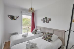 two twin beds in a room with a window at Les Petites Canailles - Proche de la Gare in Nantes
