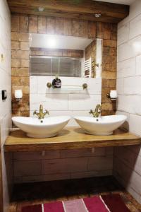 twee wastafels op een houten aanrecht in een badkamer bij Chata Styl in Hlinsko