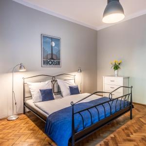 1 dormitorio con 1 cama con edredón azul en Fenna Apartments 7 minut od Rynku, en Cracovia