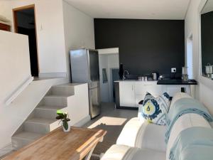 a room with a bed and a kitchen with a refrigerator at Pelicans View in Yzerfontein