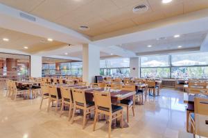 une salle à manger avec des tables et des chaises en bois dans l'établissement Hotel Gran Garbi Mar & AquaSplash, à Lloret de Mar