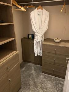 a bathroom with a robe hanging on the wall at Loxley's Devon Lodge in Brixham