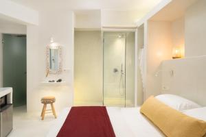 a bedroom with a shower and a bed and a stool at Edem Luxury Hotel in Oia