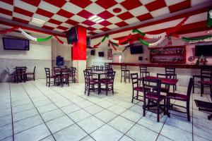 a restaurant with tables and chairs in a room at Capital O Hotel Diro, Monterrey in Monterrey