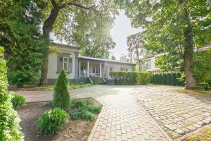 a home with a brick driveway in front of a house at Valensija in Jūrmala