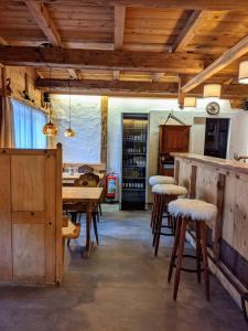 - une cuisine avec une table et des tabourets dans une pièce dans l'établissement Relais des Mélèzes, à Vissoie