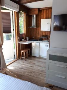 uma cozinha com electrodomésticos brancos e piso em madeira em Pokój SERCE KRYNICY em Krynica Morska