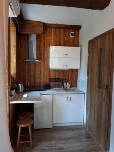 uma cozinha com armários brancos e uma parede de madeira em Pokój SERCE KRYNICY em Krynica Morska