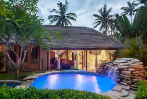 a swimming pool in front of a house at Dolcemare Resort in Gili Islands