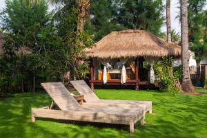 twee stoelen en een tuinhuisje in de tuin bij Dolcemare Resort in Gili Air