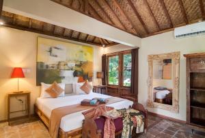 1 dormitorio con cama, mesa y espejo en Dolcemare Resort en Gili Air