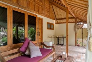 una stanza con un divano viola su un patio di Dolcemare Resort a Gili Air