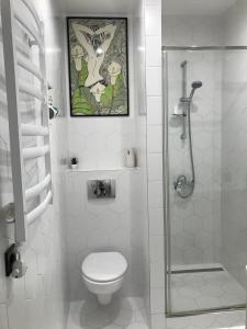 uma casa de banho branca com um WC e um chuveiro em Two level appartment in the centre of Lviv em Lviv