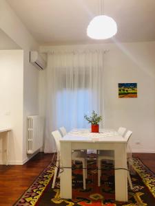 una sala da pranzo con tavolo e sedie bianchi di CONCORDIA LUXURY a Agrigento