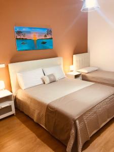 1 dormitorio con 1 cama y una pintura en la pared en CONCORDIA LUXURY en Agrigento