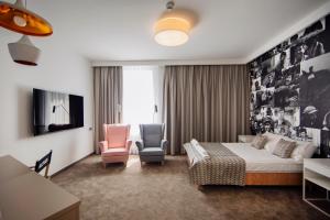 アレクサンドルフ・ウツキにあるHotel Jan Sanderのベッド1台と椅子2脚が備わるホテルルームです。