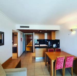 een keuken en eetkamer met een tafel en stoelen bij Monte Gordo Hotel Apartamentos & Spa in Monte Gordo
