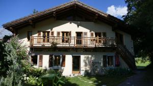 een wit huis met een balkon en een veranda bij Magnifique chalet dans la vallée de Chamonix in Servoz