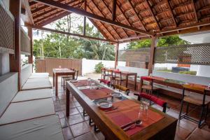 un restaurante con mesas y sillas de madera y un techo en Lost & Found - Kandy, en Kandy