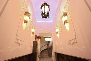 a hallway with a chandelier and stairs in a building at 7th HEAVEN Vienna Center Apartments in Vienna