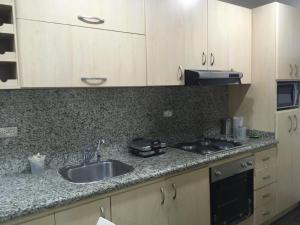 uma cozinha com um lavatório e uma bancada em apartosuite em Caracas