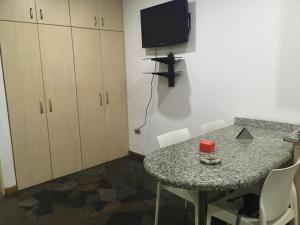 a room with a table with chairs and a television at apartosuite in Caracas