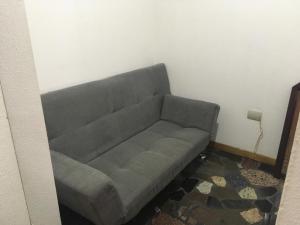 a gray couch in a corner of a room at apartosuite in Caracas